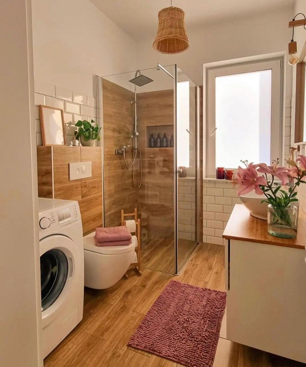 Cozy bathroom with shower, washing machine, and wood accents, decorated with pink flowers