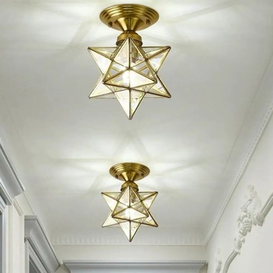 Two ceiling-mounted star-shaped pendant lights with transparent geometric designs