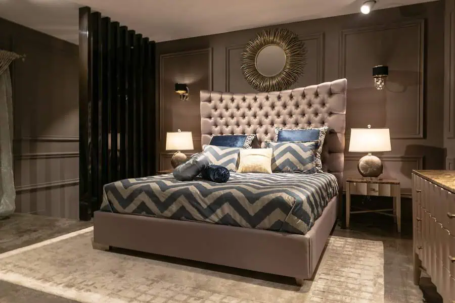 Luxurious bedroom with a tufted headboard, chevron-patterned bedding, and elegant decor.