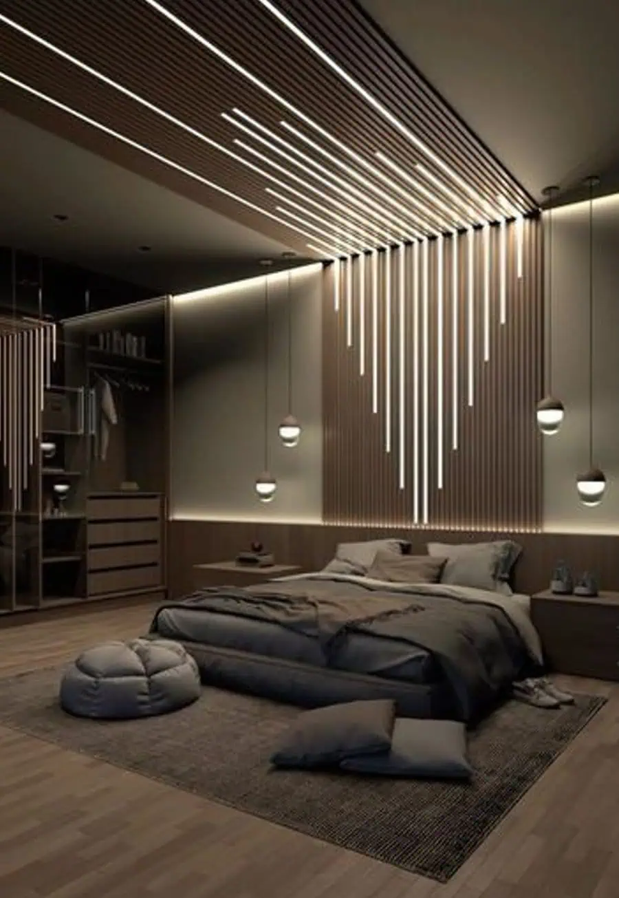 Modern bedroom with sleek lighting, large bed, minimalist decor, and a cozy seating area on the floor.