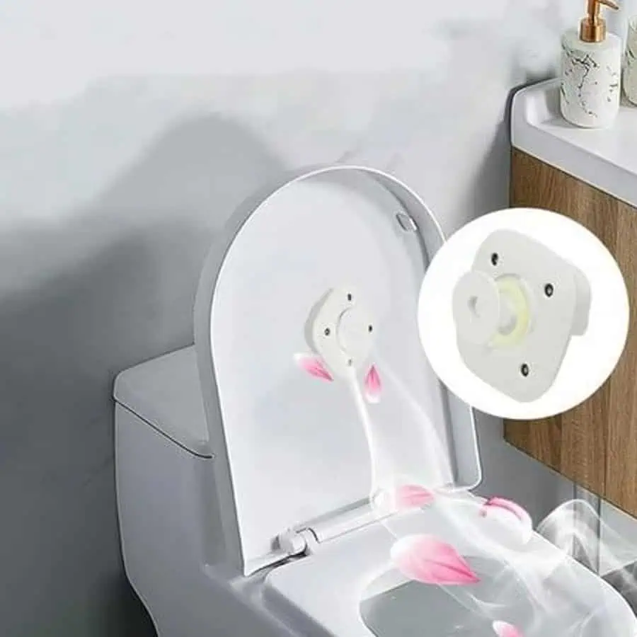 Toilet seat with an air freshener device attached to the inside of the lid releasing fragrance