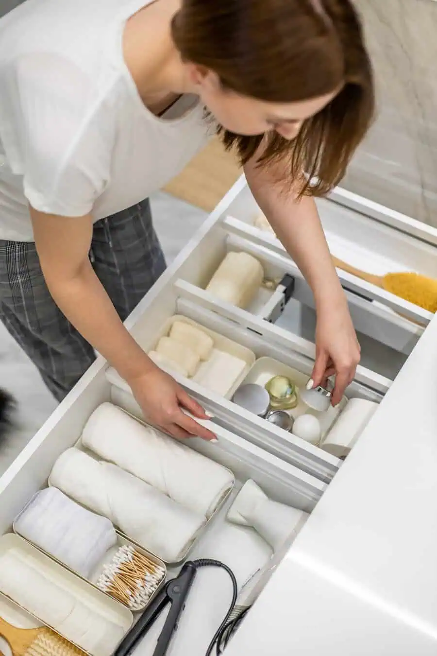 Organizing bathroom drawer with neatly arranged towels, soaps, and toiletries