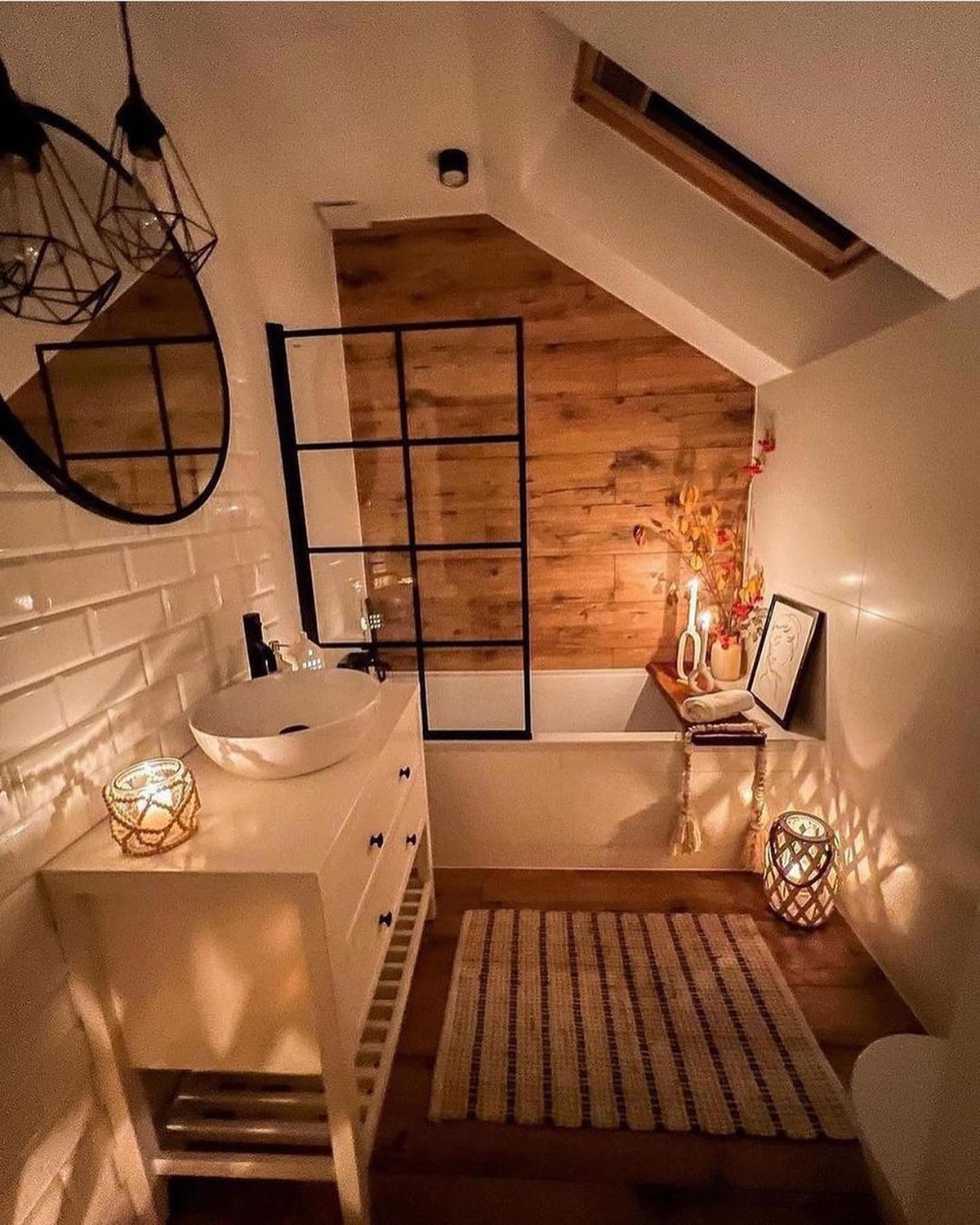 Hygge-inspired Cozy bathroom with wooden accents, candles, a round mirror, and a rug