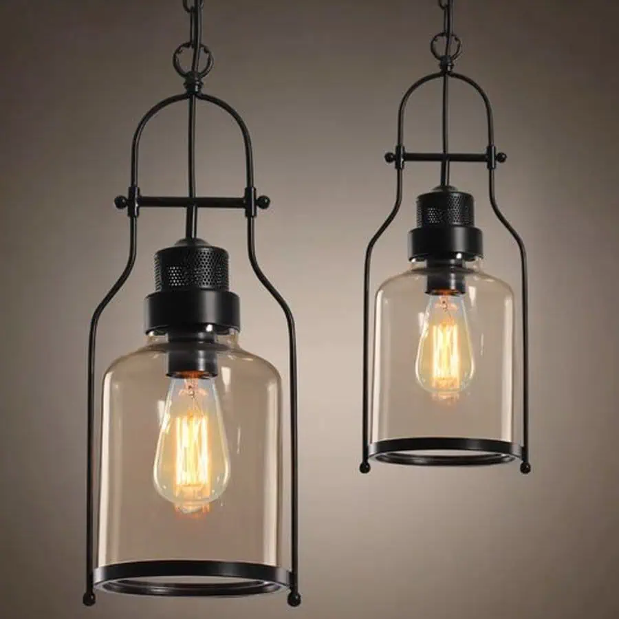 Two industrial-style hanging pendant lights with exposed filament bulbs enclosed in glass and metal housing