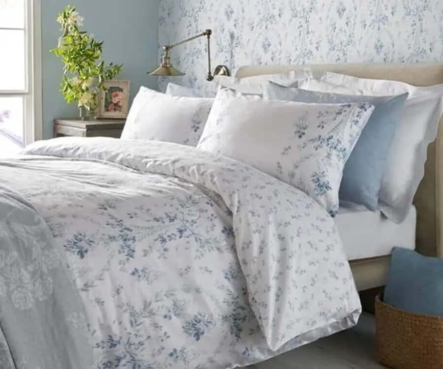 Cozy bedroom featuring floral-patterned bedding, rustic decor, and a plant near the window