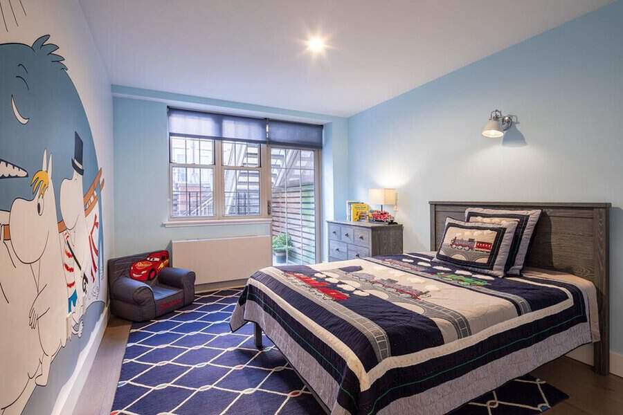 A child's bedroom featuring cartoon-themed decor, bed, dresser, and a small armchair by the window