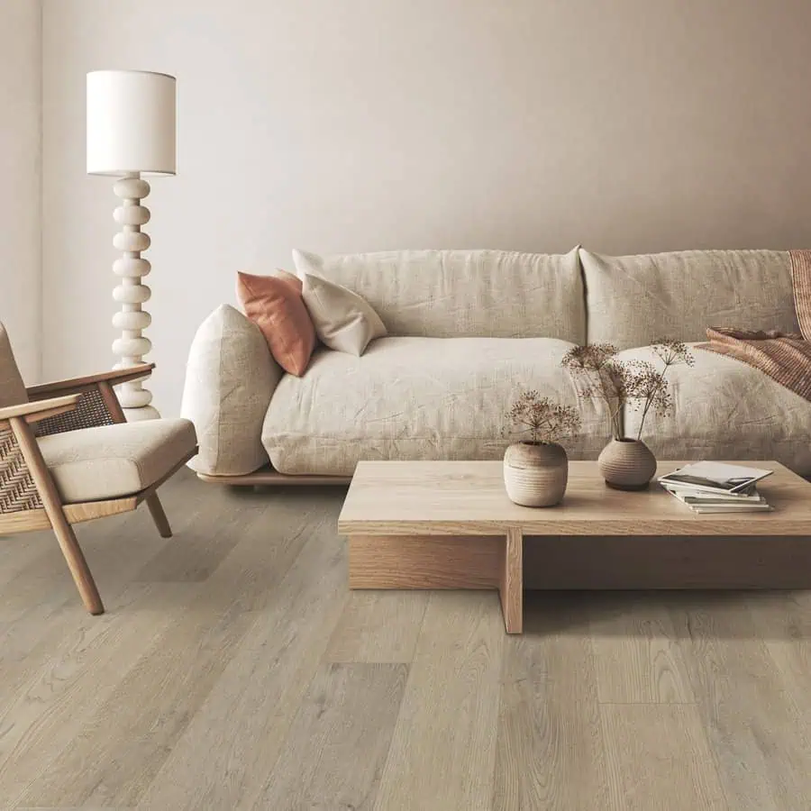 Modern living room featuring a beige sofa, wooden coffee table, wicker chair, floor lamp, and dried flower decorations