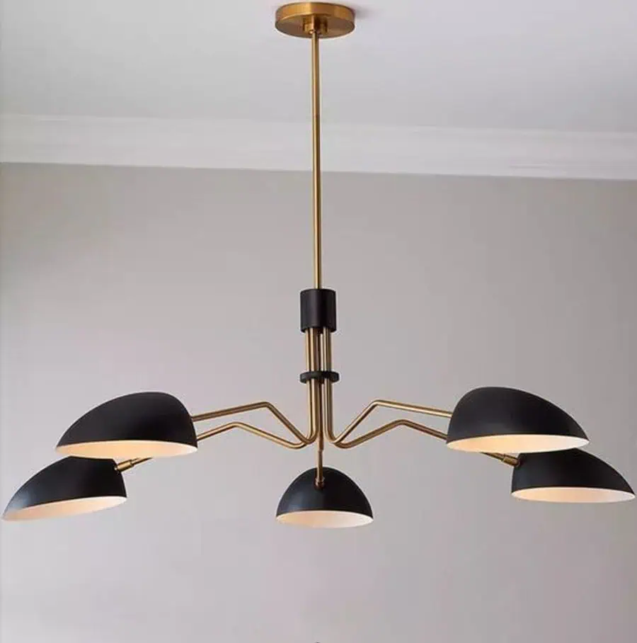 Modern gold and black chandelier with four dome-shaped lights hangs from a ceiling