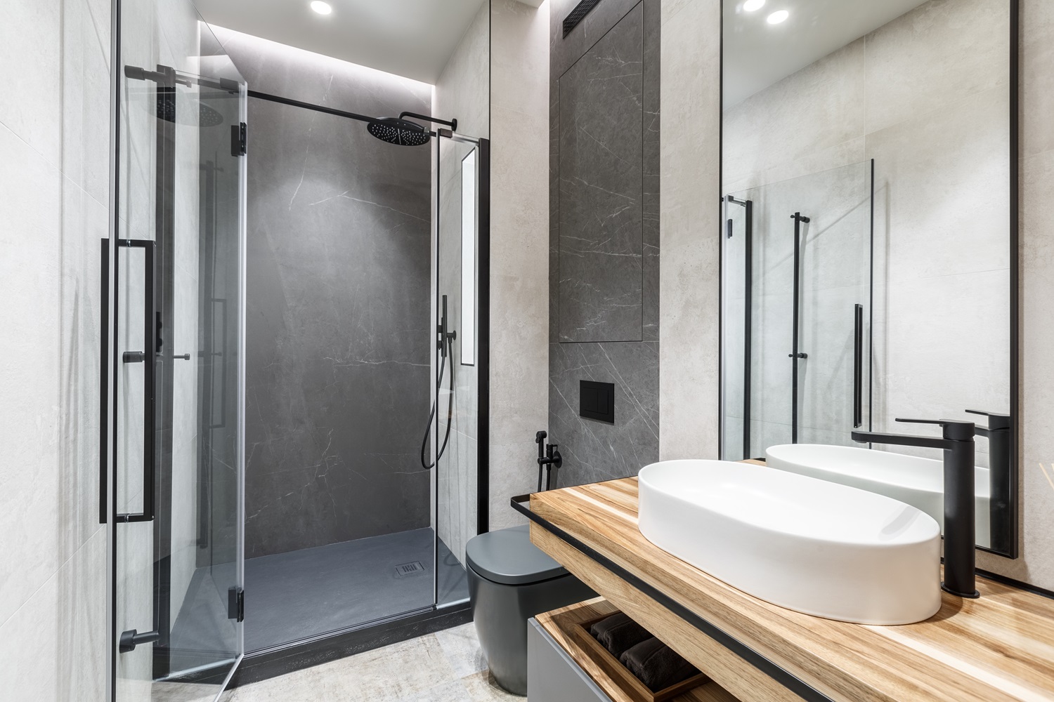 Modern bathroom with a glass shower and sleek white sink on a wooden countertop