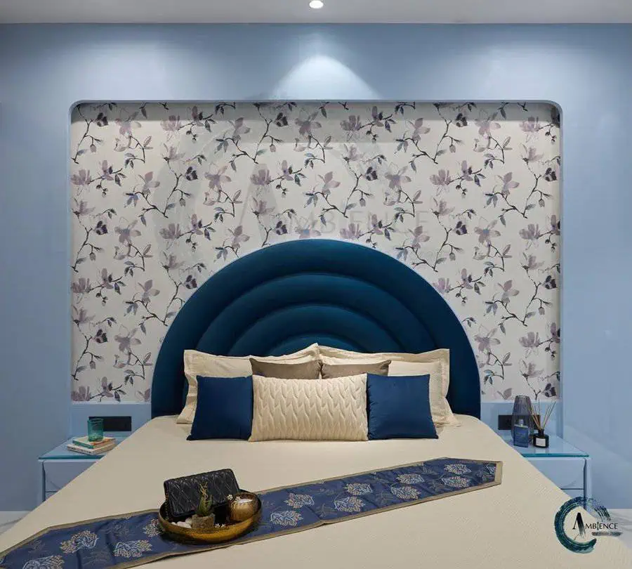 Modern bedroom with floral wallpaper, blue accents, and a stylish navy headboard