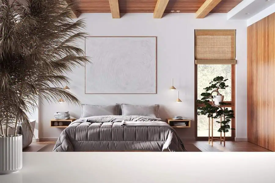 Modern bedroom with a neatly made bed, wooden accents, hanging lights, potted plants, and a large artwork above the headboard