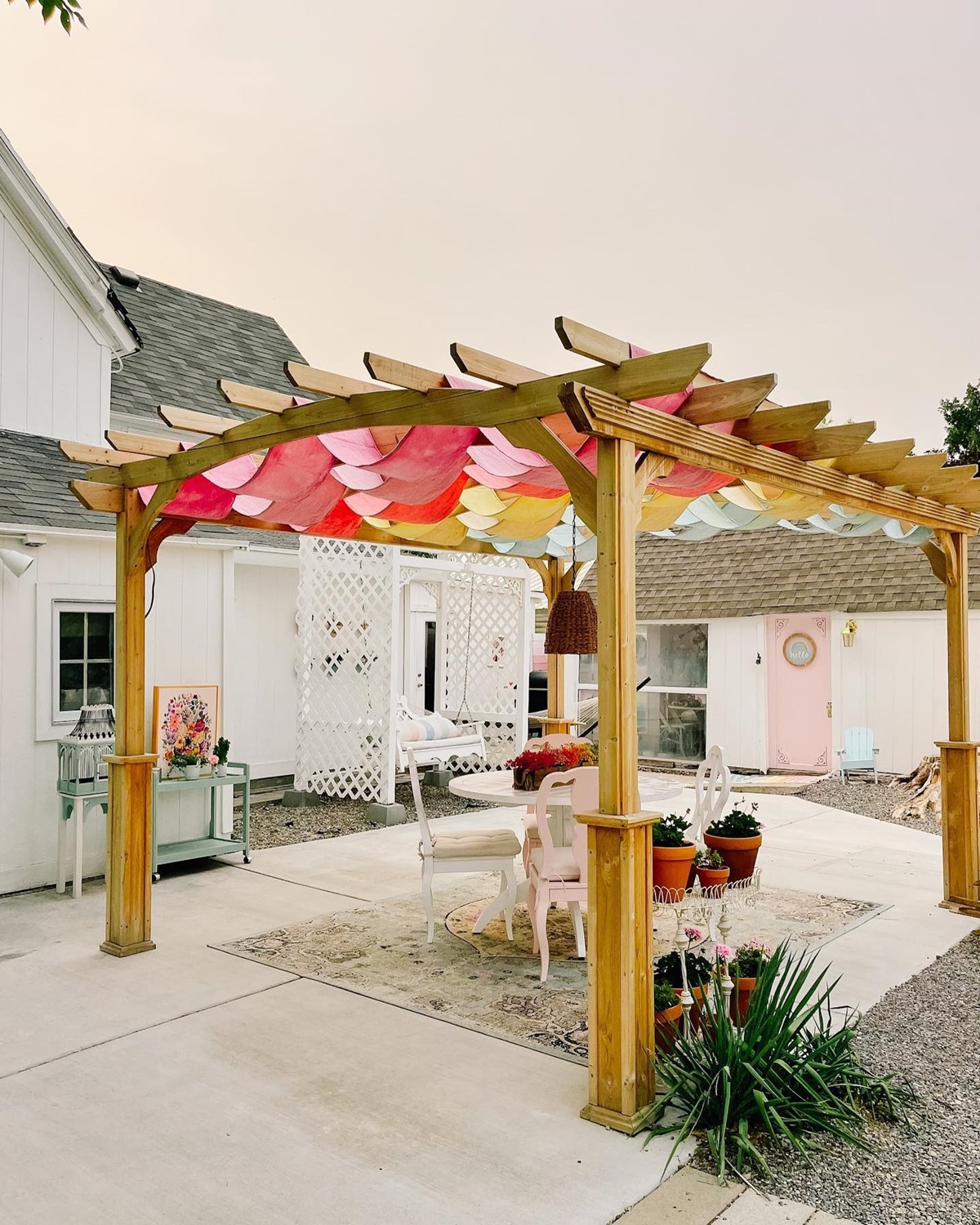 Wooden pergola with colorful canopy in a charming backyard setting