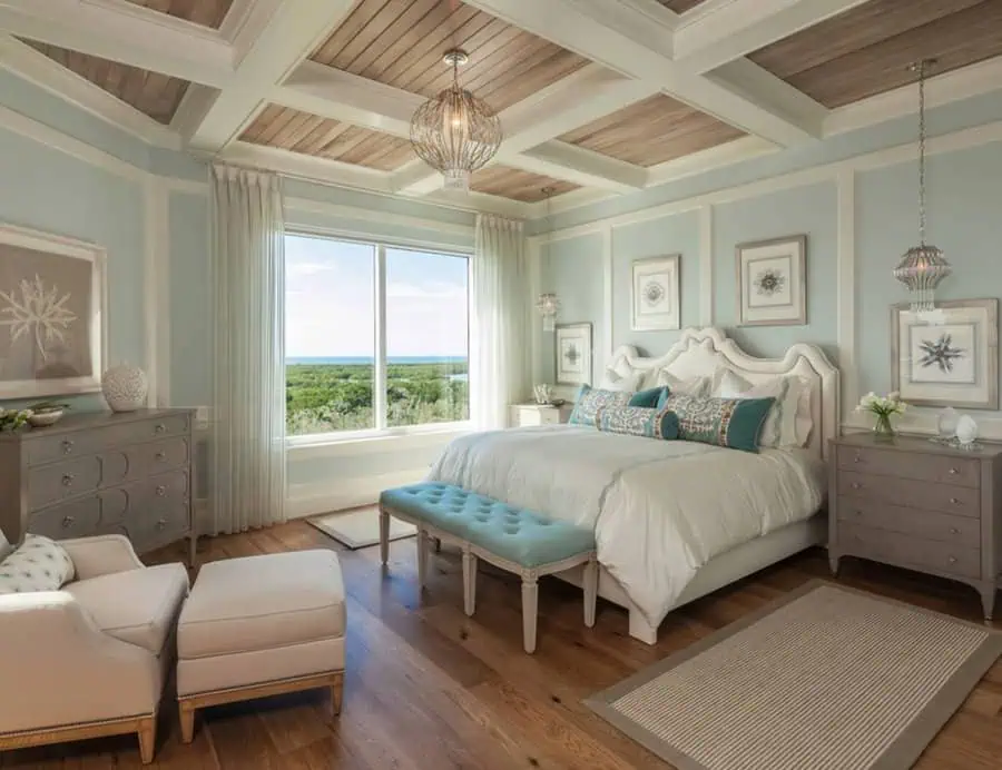 Elegant bedroom featuring a large bed with light blue accents, a wooden ceiling, and a scenic window view