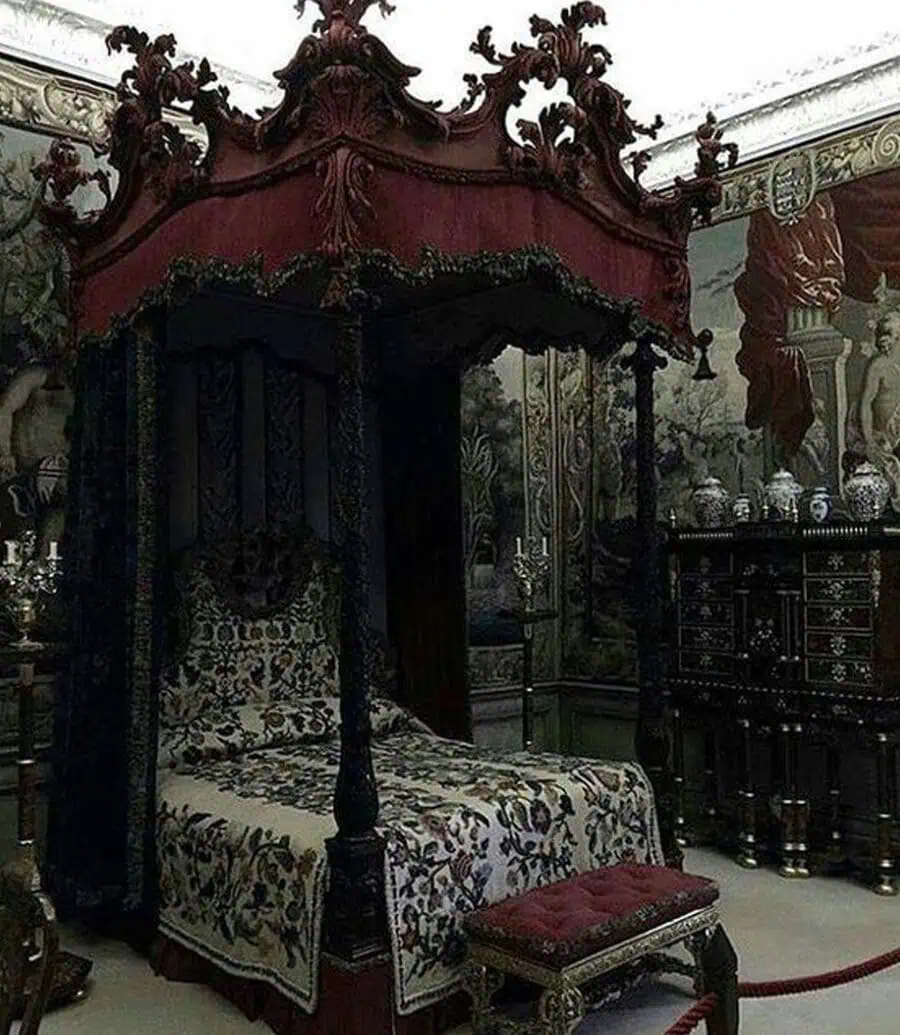 Opulent, dark-themed bedroom with an ornate canopy bed, elaborate tapestries, and intricate woodwork.