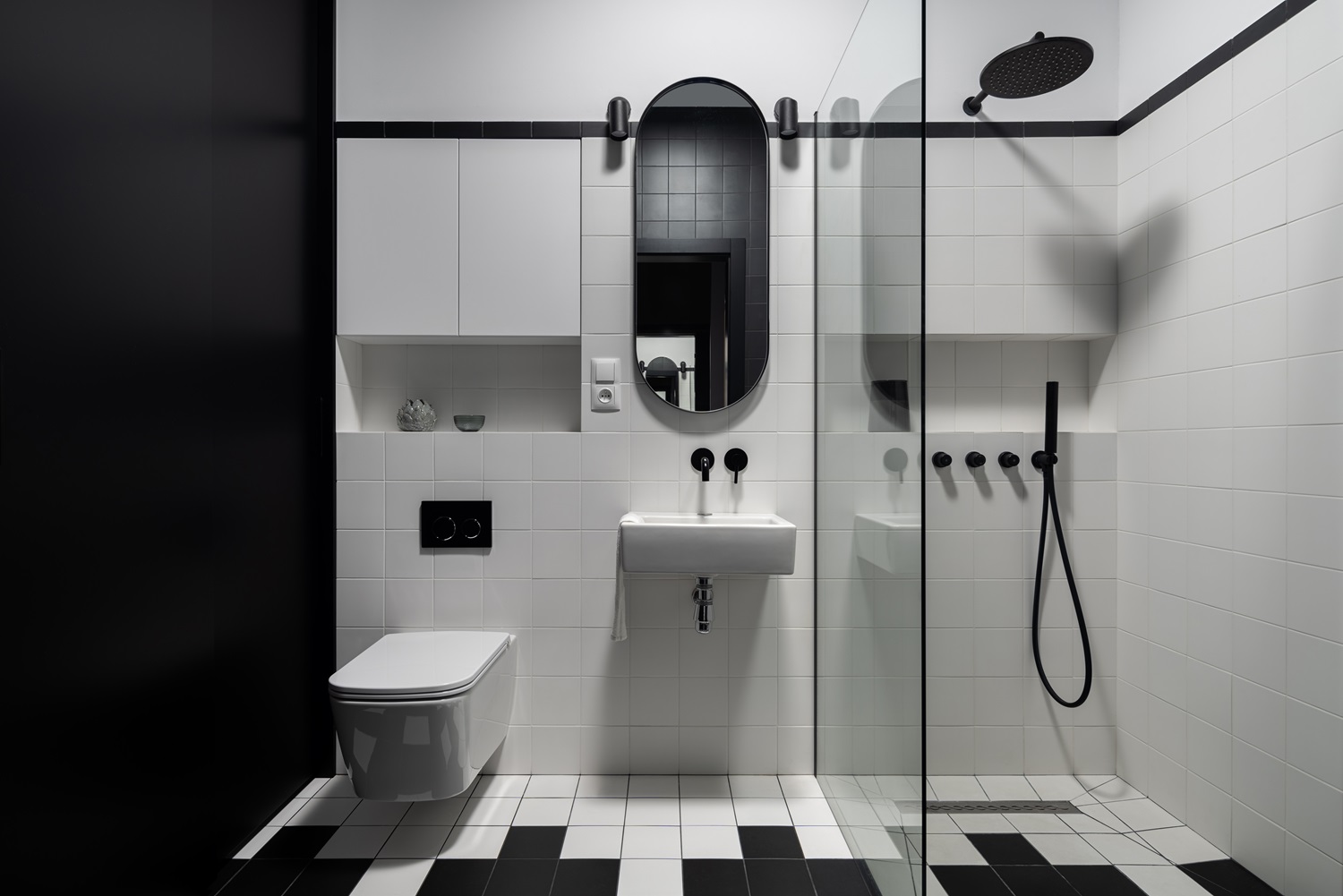 Modern bathroom featuring a wall-mounted sink, toilet, and walk-in shower