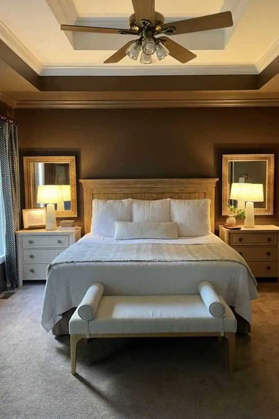 Bedroom with a bed, two bedside tables with lamps, a bench at the foot of the bed, and a ceiling fan.