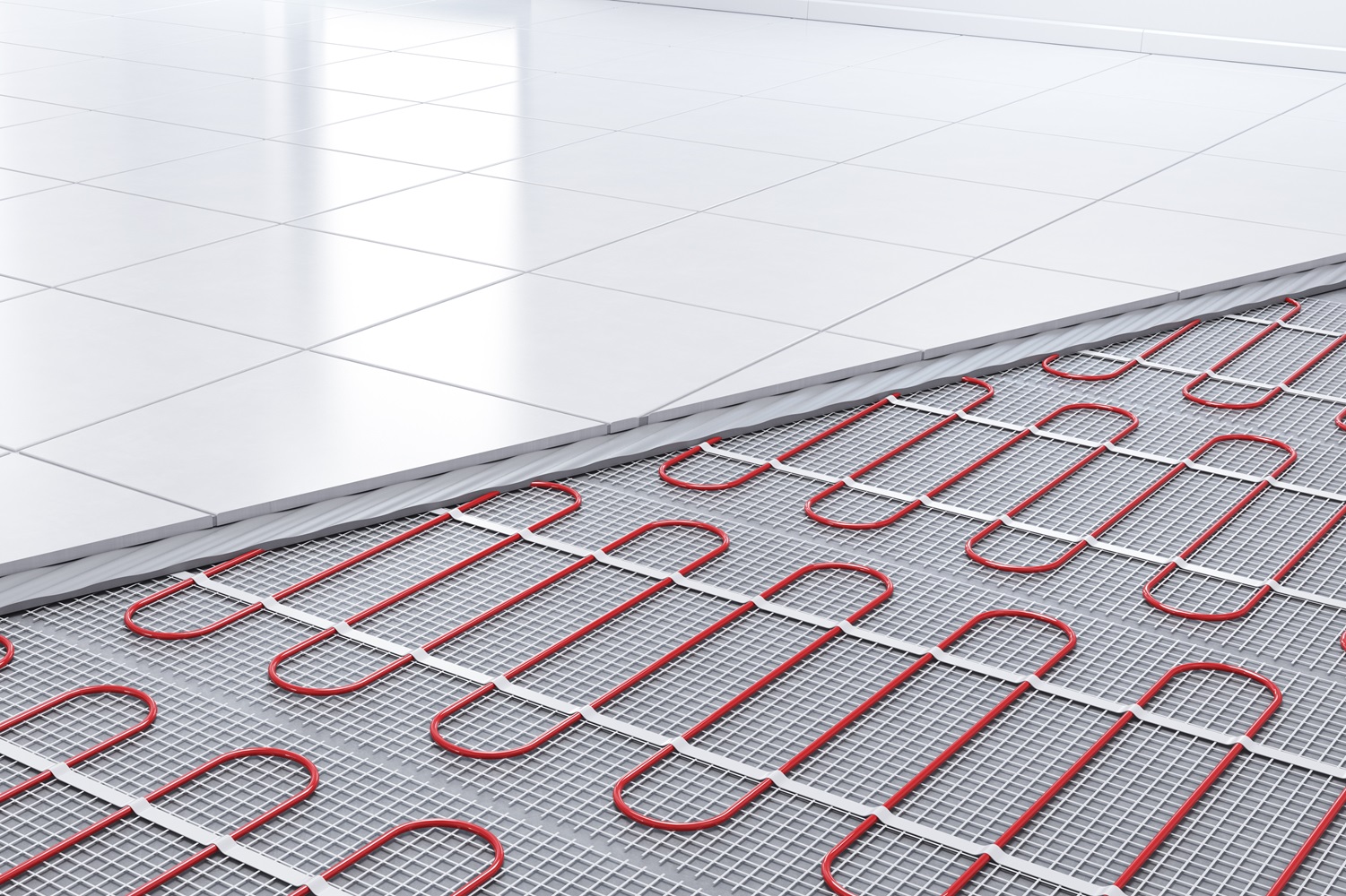 Close-up of red underfloor heating pipes beneath a white tiled floor