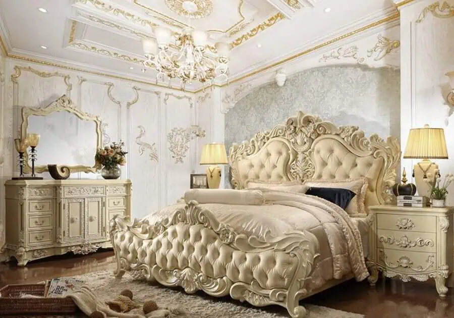 Ornate bedroom featuring elegant furniture such as a tufted bed, opulent dresser, mirrors, lamps, and an intricate ceiling design