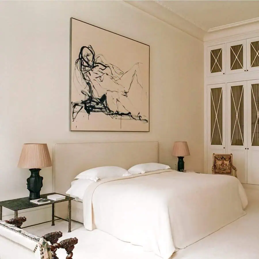 Elegant bedroom with neutral tones, a minimalist bed, abstract wall art, and sophisticated decor.