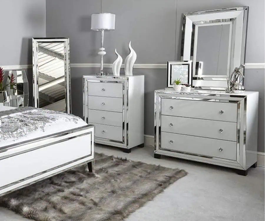 Modern bedroom with mirrored furniture, including bed, dresser, nightstand, and a standing mirror.