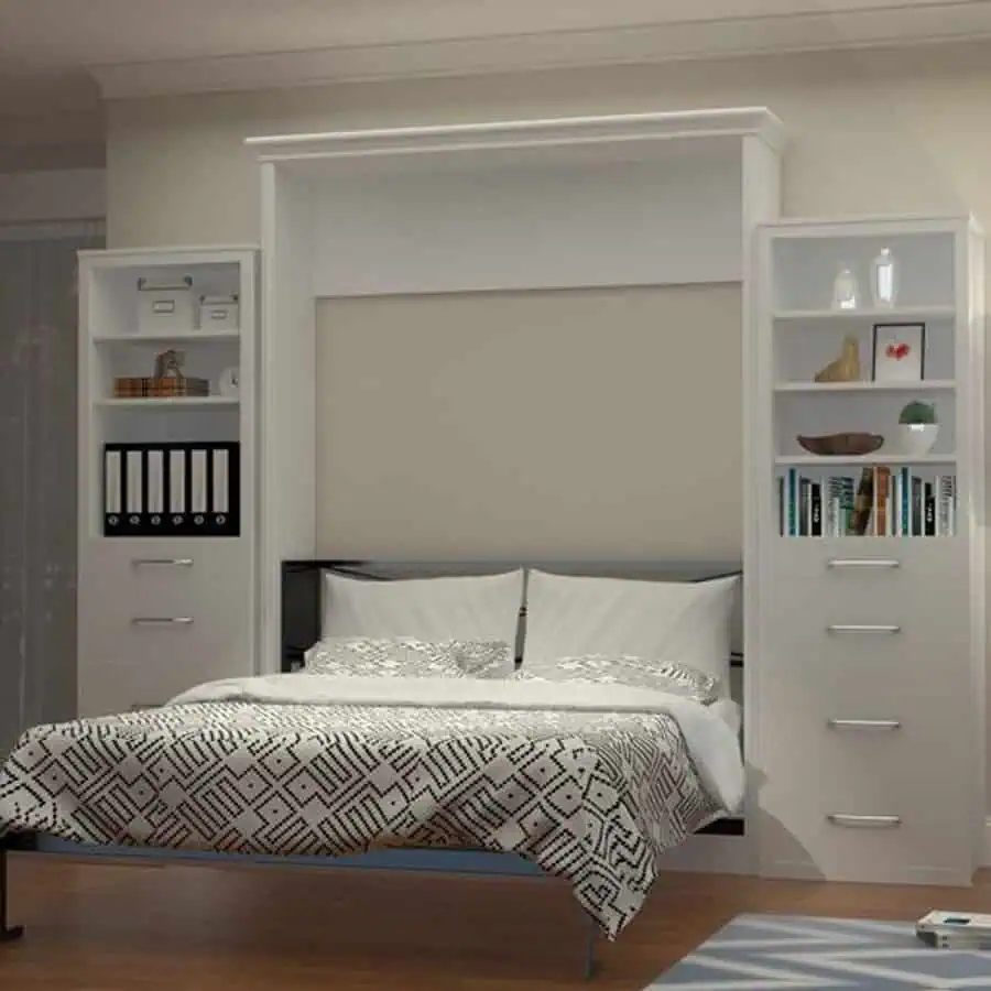 A modern murphy bed with white storage cabinets on either side, featuring a patterned bedspread