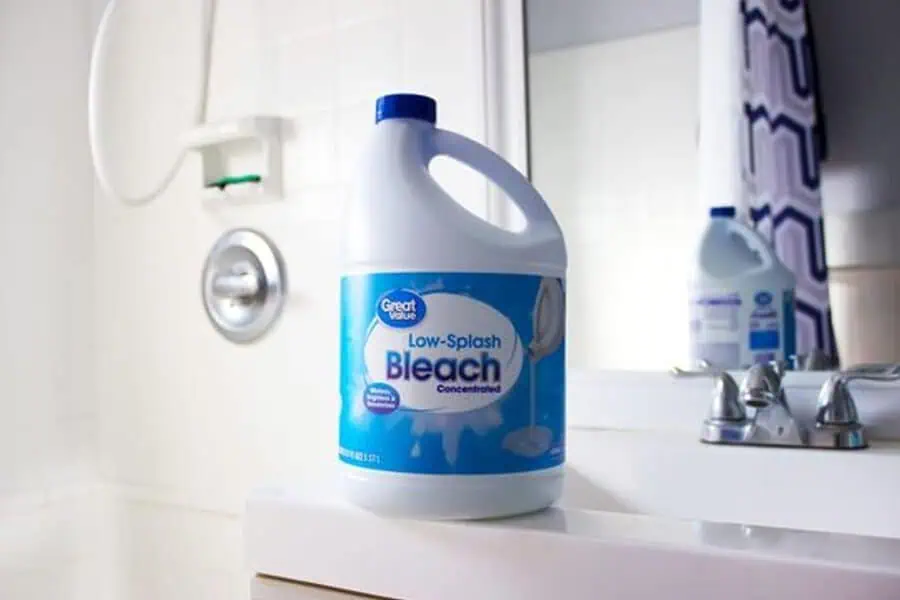 A bottle of Great Value Low-Splash Bleach on a bathroom counter near a sink and a mirror