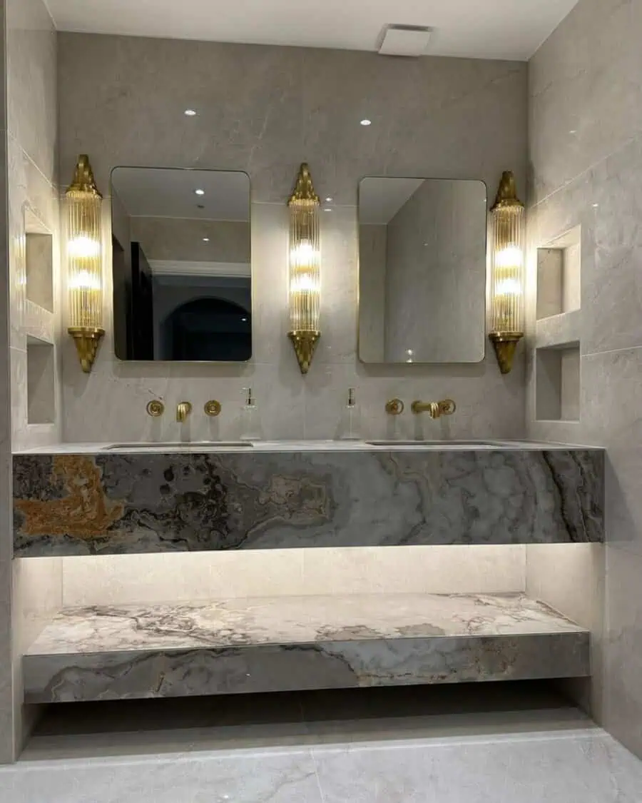 Elegant Art Deco bathroom with marble vanity, gold fixtures, and vintage-style wall sconces.