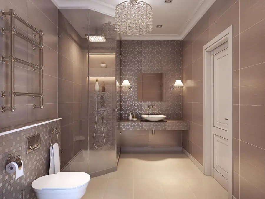 Elegant Art Deco bathroom with mosaic wall tiles, glass shower, chandelier, and floating vanity.