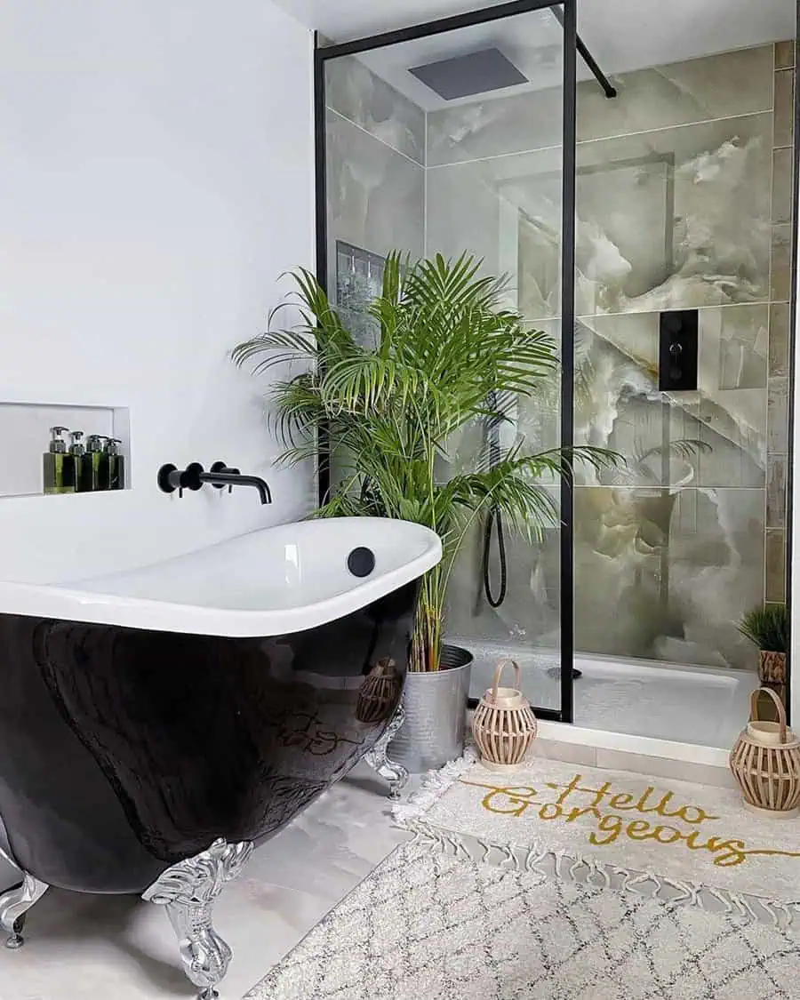 Modern bathroom with a black clawfoot tub, bamboo palm plant, and a glass-enclosed shower.