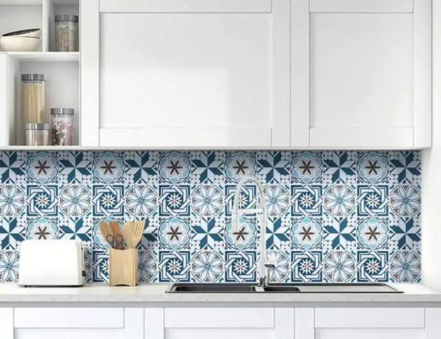 A kitchen with white cabinetry and a bold, geometric blue and white patterned backsplash.