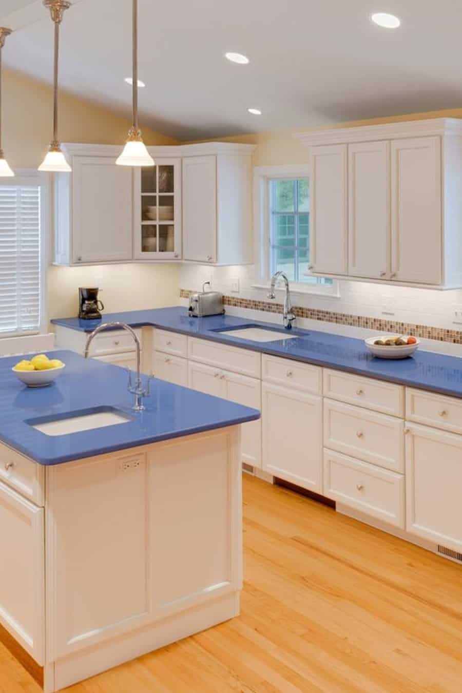 Modern kitchen with blue countertops white cabinets and wooden flooring