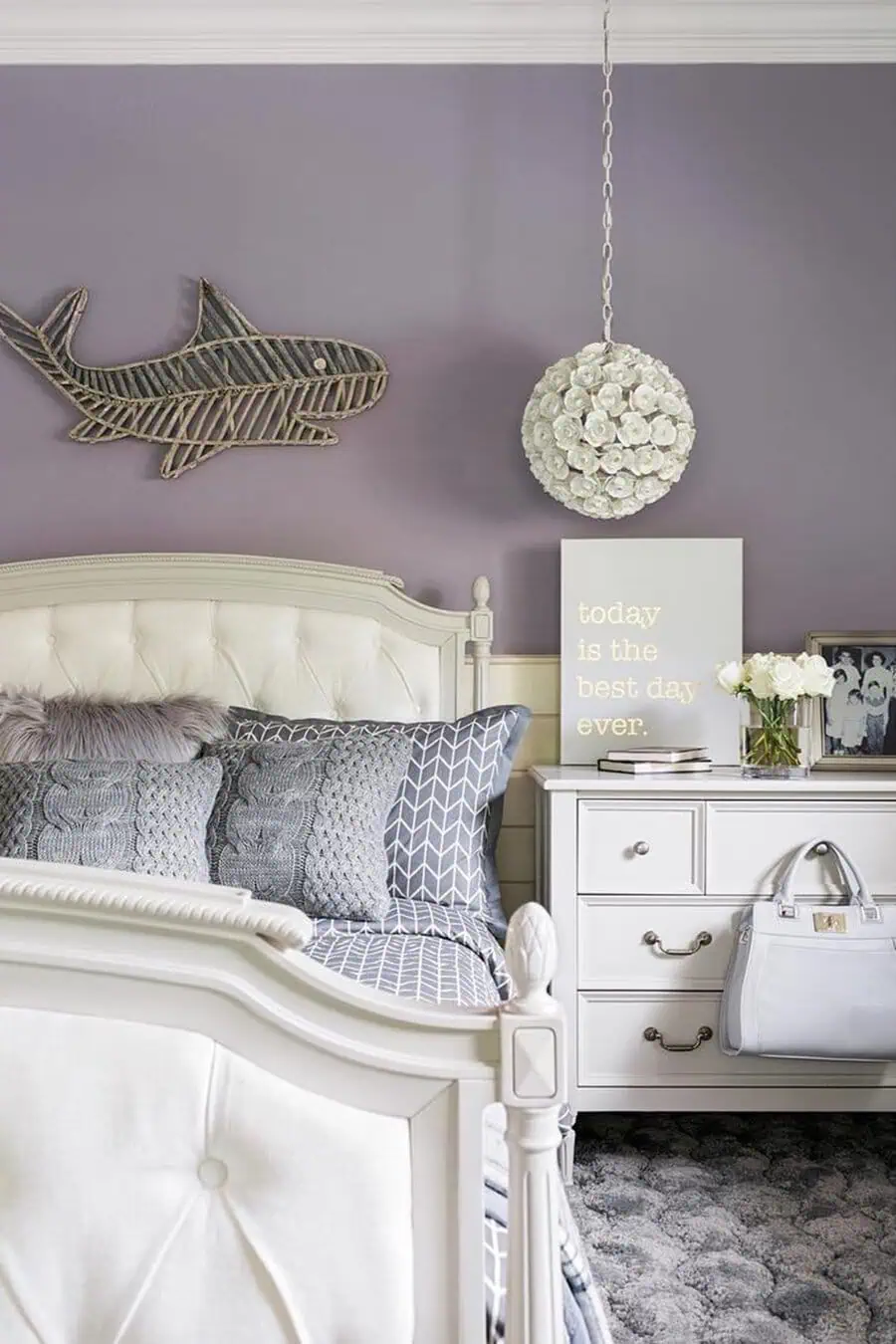 Chic bedroom with lavender walls, textured pillows, and decorative shark wall art.