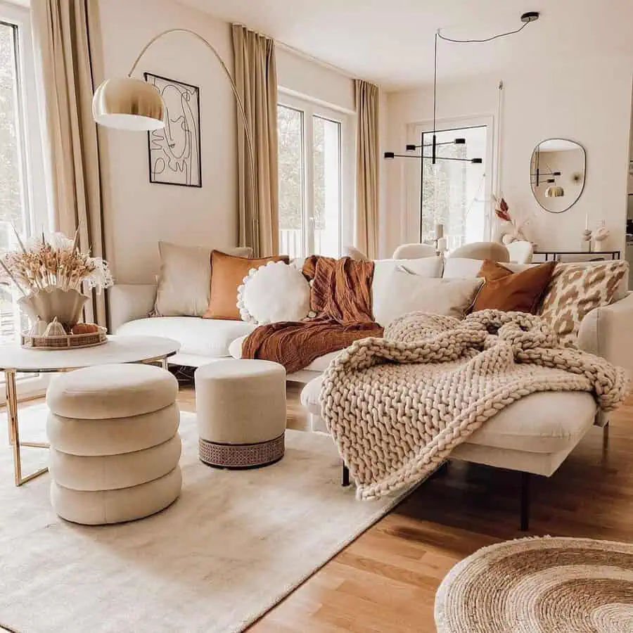 Warm living room with neutral furniture, cozy throw blankets, and soft natural lighting.