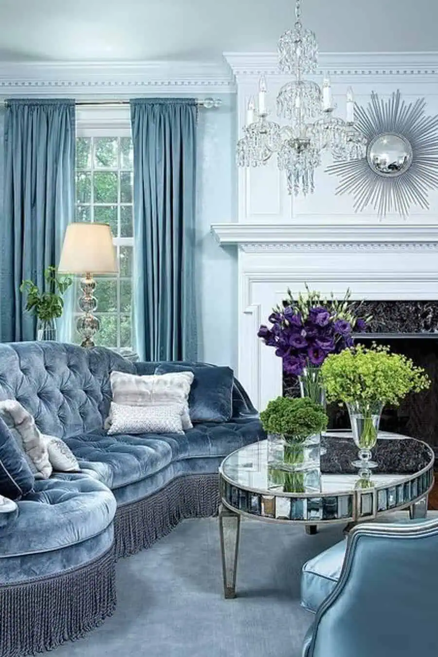 The rich blue tones paired with reflective surfaces in this living room create a sense of depth and sophistication.