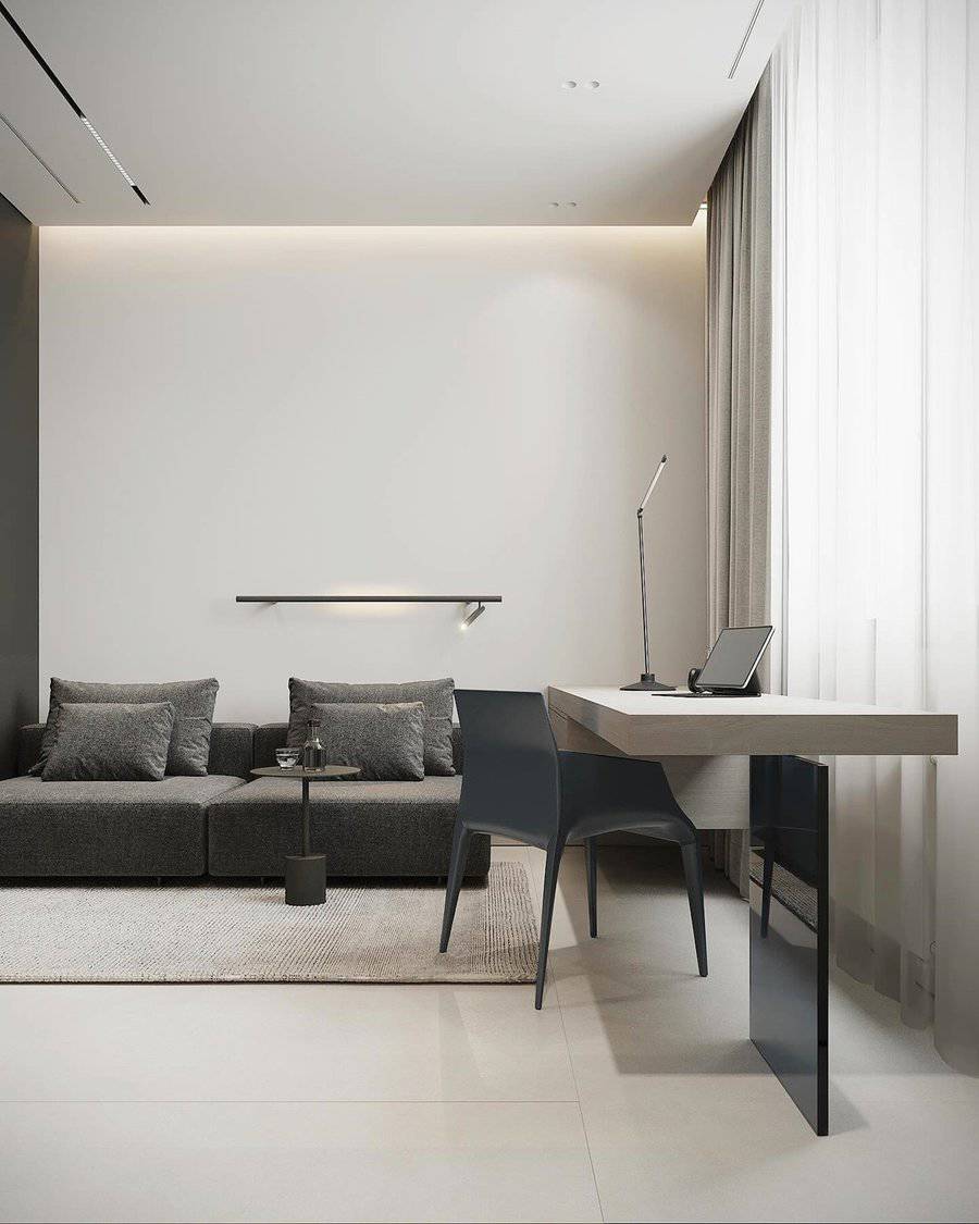 Modern living space with a sleek gray sofa, minimalist desk, and soft natural lighting.