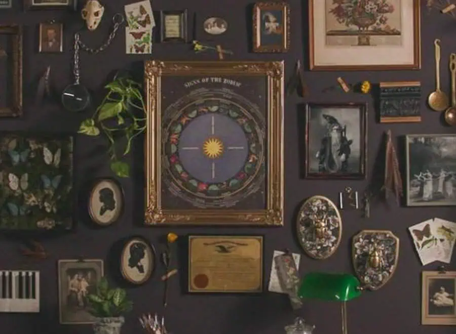 A curated gallery wall featuring vintage frames, botanical prints, and antique memorabilia. The eclectic mix includes butterflies, zodiac signs, and silhouettes.