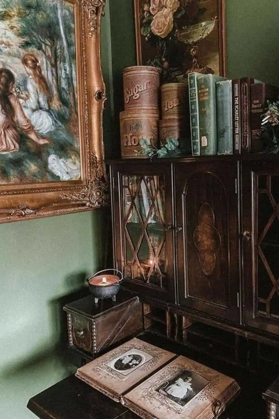 A vintage corner featuring an antique cabinet, old books, and a framed painting.