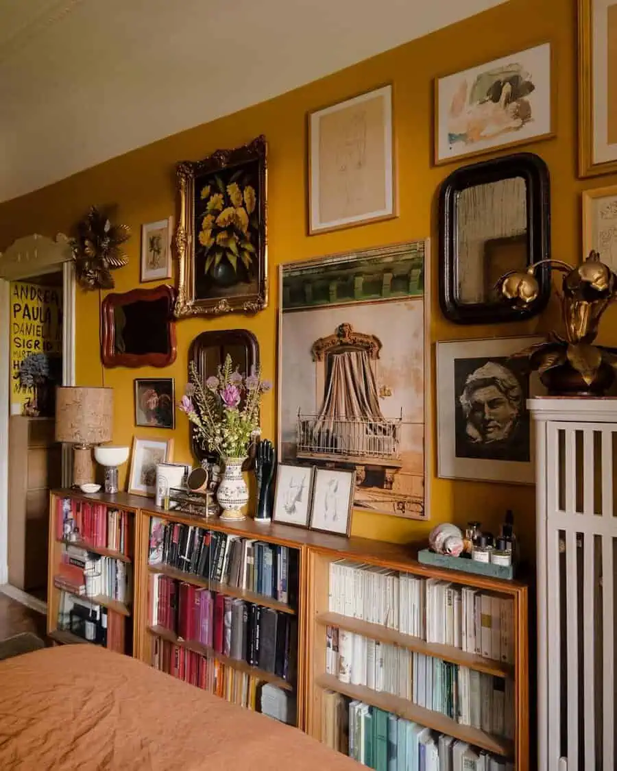 Eclectic gallery wall with vintage art, ornate frames, and bookshelves in a cozy bedroom setting.