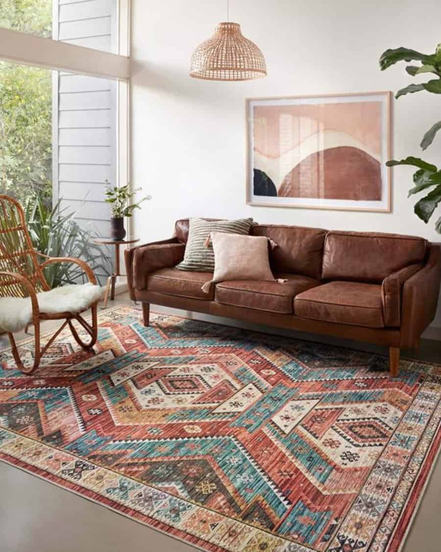 Eclectic living room featuring a leather sofa, geometric rug, and rattan pendant light.