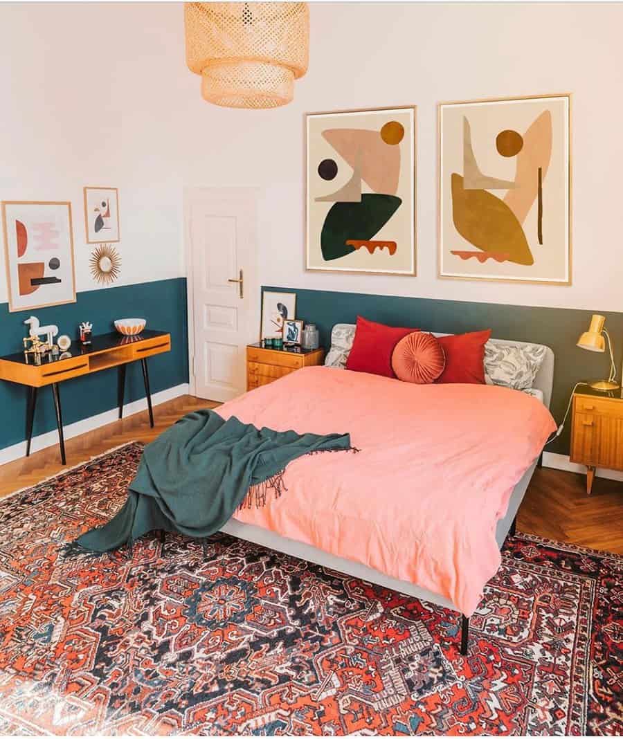 Colorful bedroom with abstract artwork gallery wall, patterned rug, and mid-century modern decor.