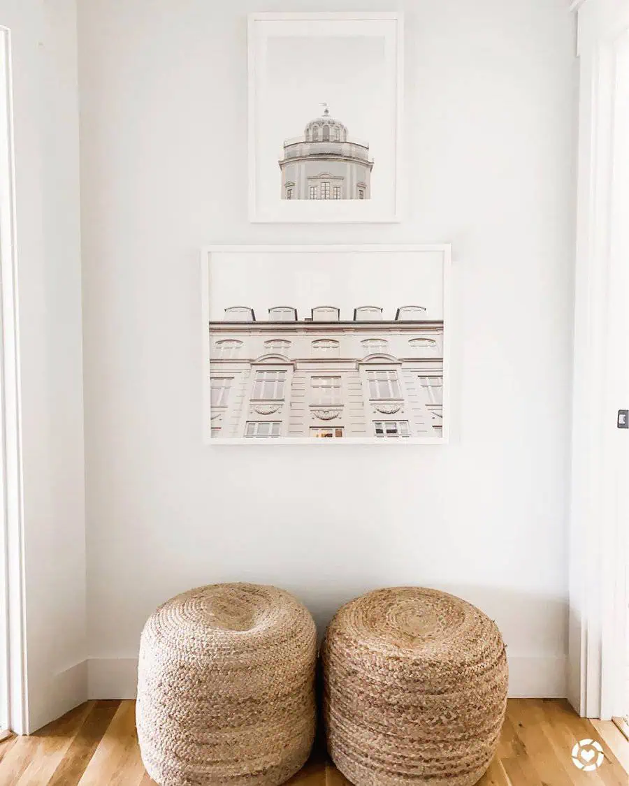 Minimalist hallway with architectural gallery wall, woven poufs, and bright white decor.