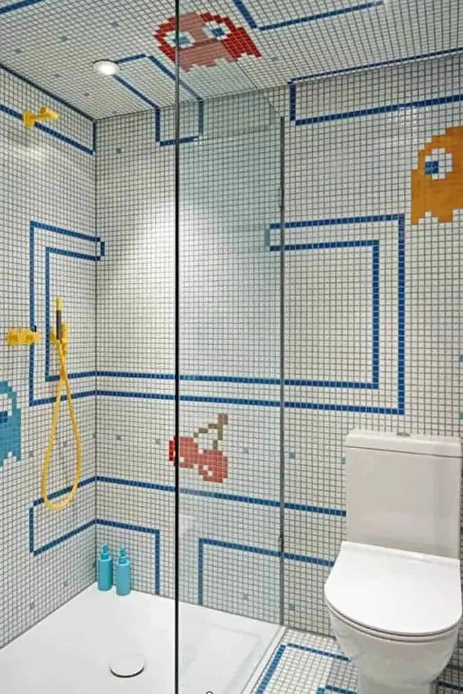 Pixelated video game-inspired mosaic tiles with yellow showerhead and glass enclosure.