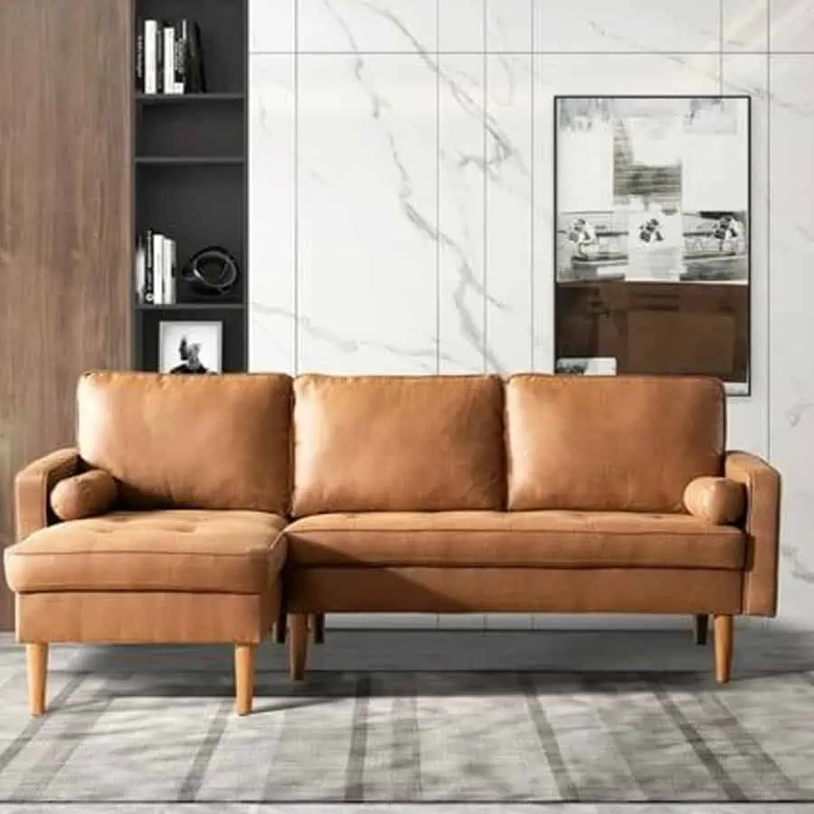 Mid-century modern living room with a tan leather sectional and marble accent wall.