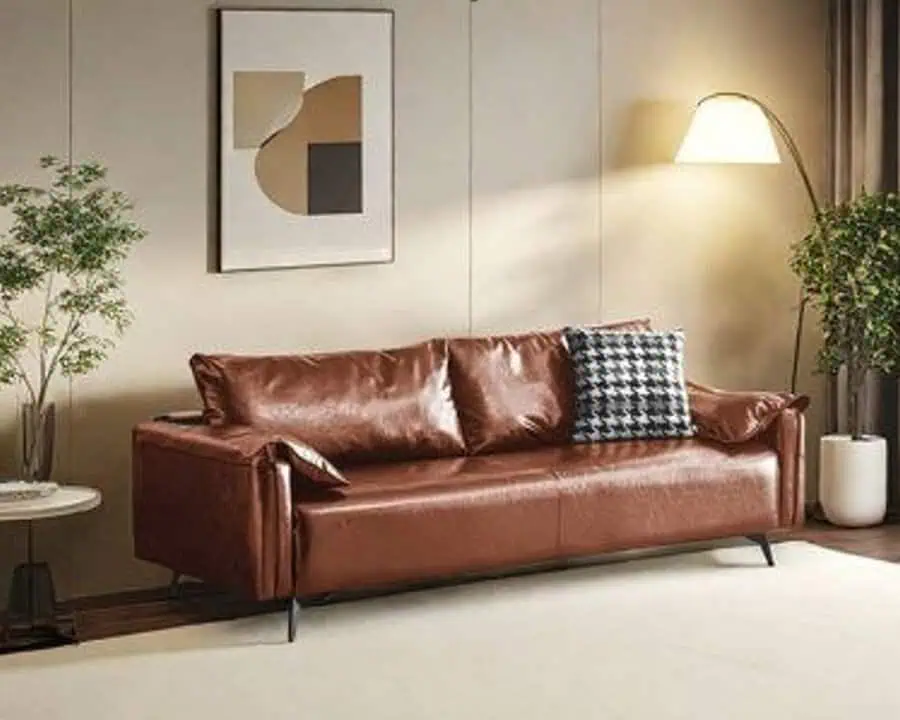 Brown leather sofa in a minimalist living room with abstract wall art and floor lamp.