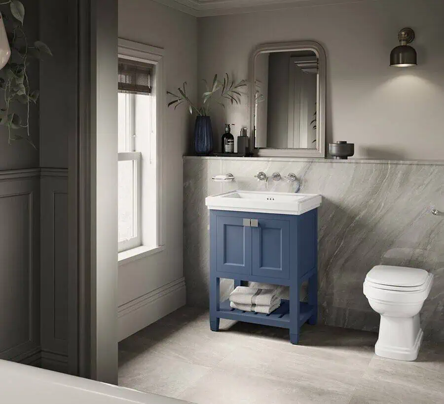 Modern bathroom with a blue vanity, marble wall, and a sleek, elegant white toilet.