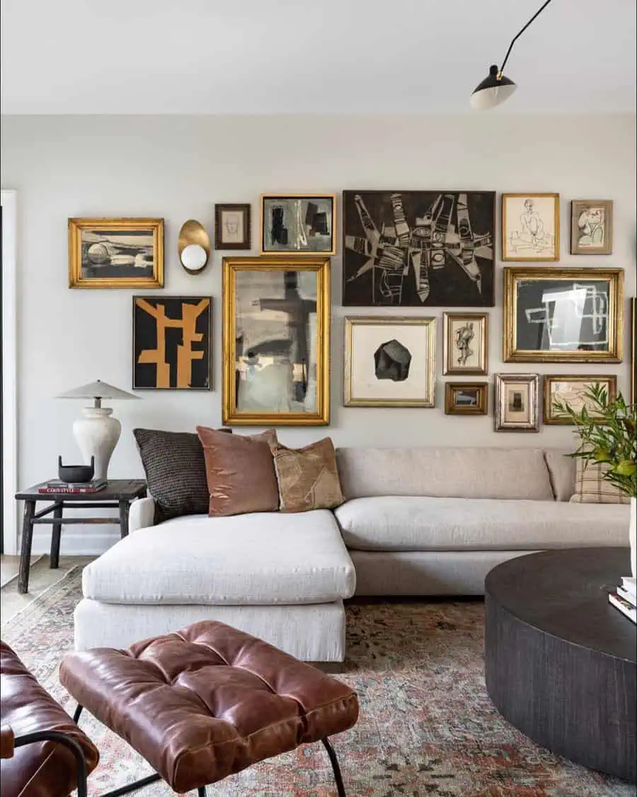 Chic living room with modern art gallery wall, beige sectional sofa, and leather tufted ottomans.