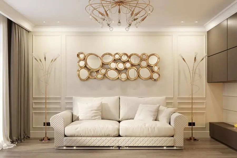 Modern living room with a white sofa, gold accent decor, circular wall art, and a stylish chandelier.