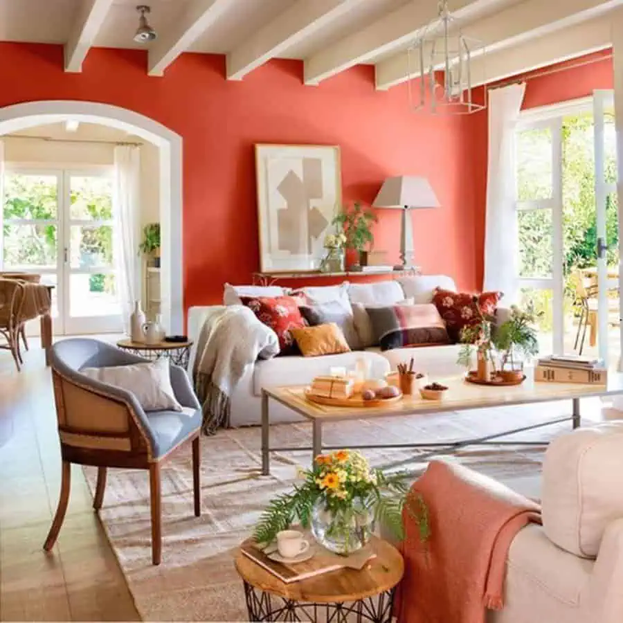 Cozy living room with red accent wall, neutral furniture, and wooden decor elements.