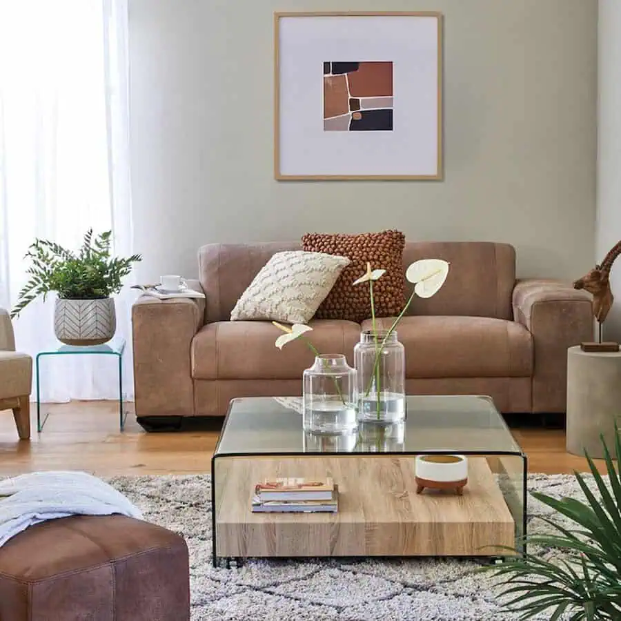 Neutral-toned living room with a leather sofa, glass coffee table, and minimalist decor.