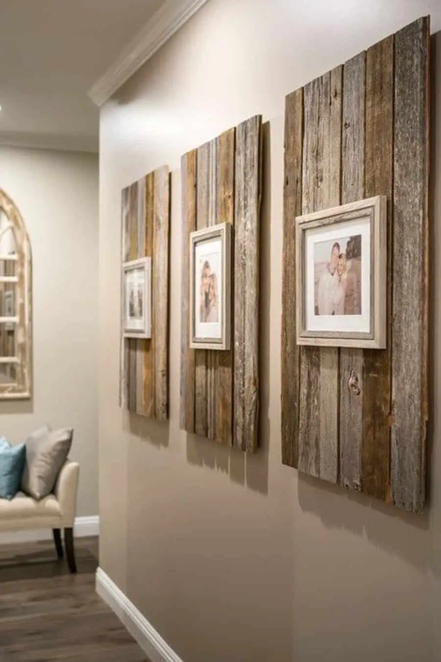 Rustic farmhouse gallery wall with reclaimed wood frames and family photos in a cozy hallway.